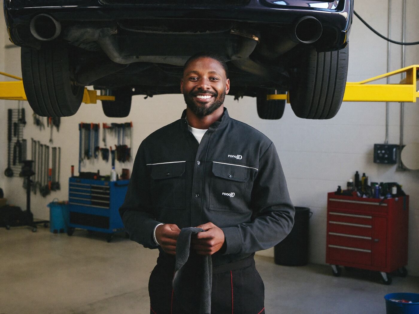 Mechanic beside a car on a lift in a clean garage