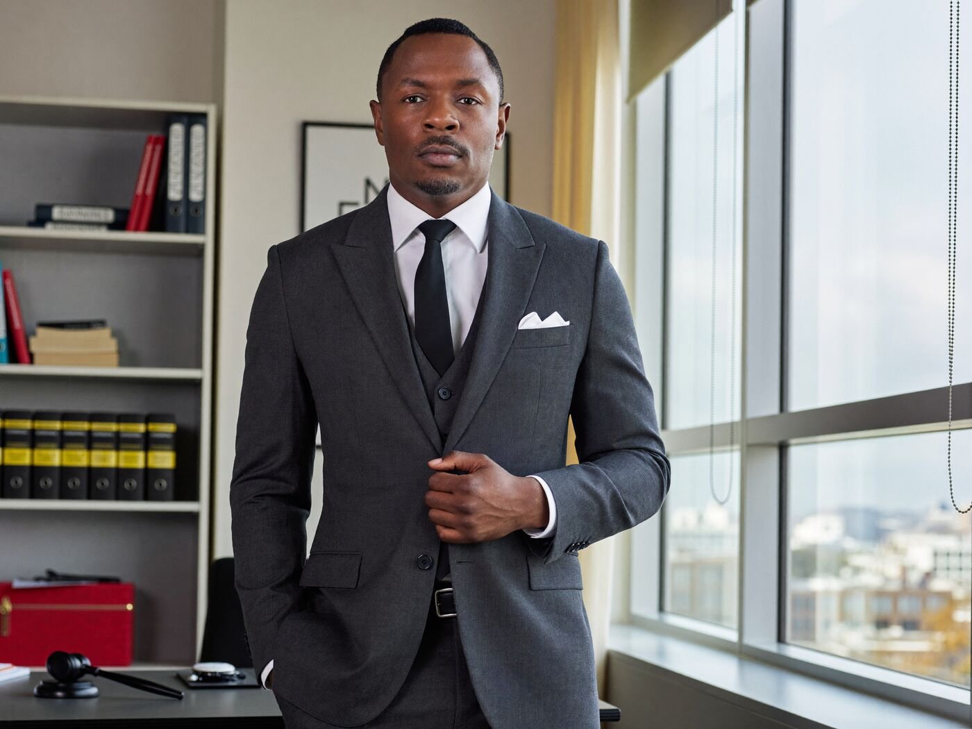 Attorney in a charcoal suit standing in a modern office
