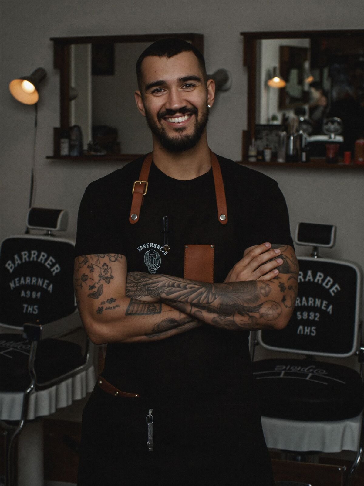 Barber with crossed arms inside his barbershop