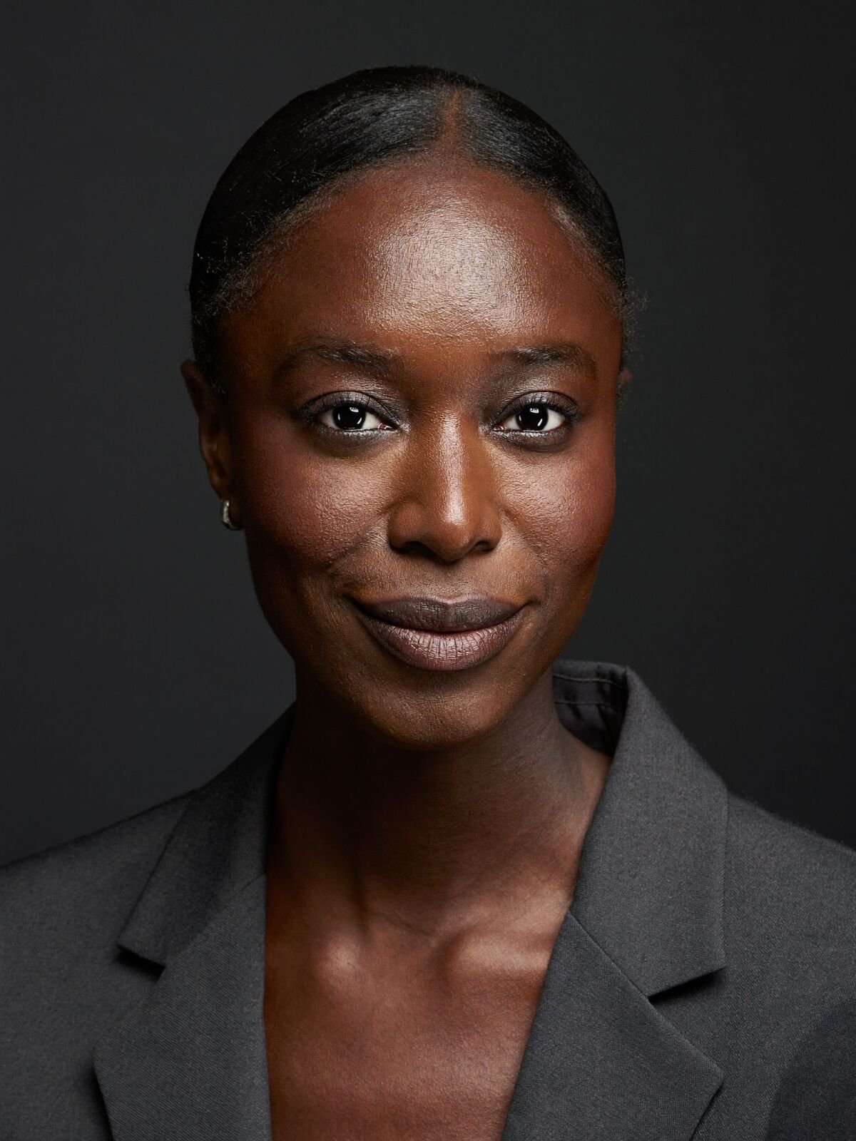 Executive headshot of a woman in a charcoal blazer